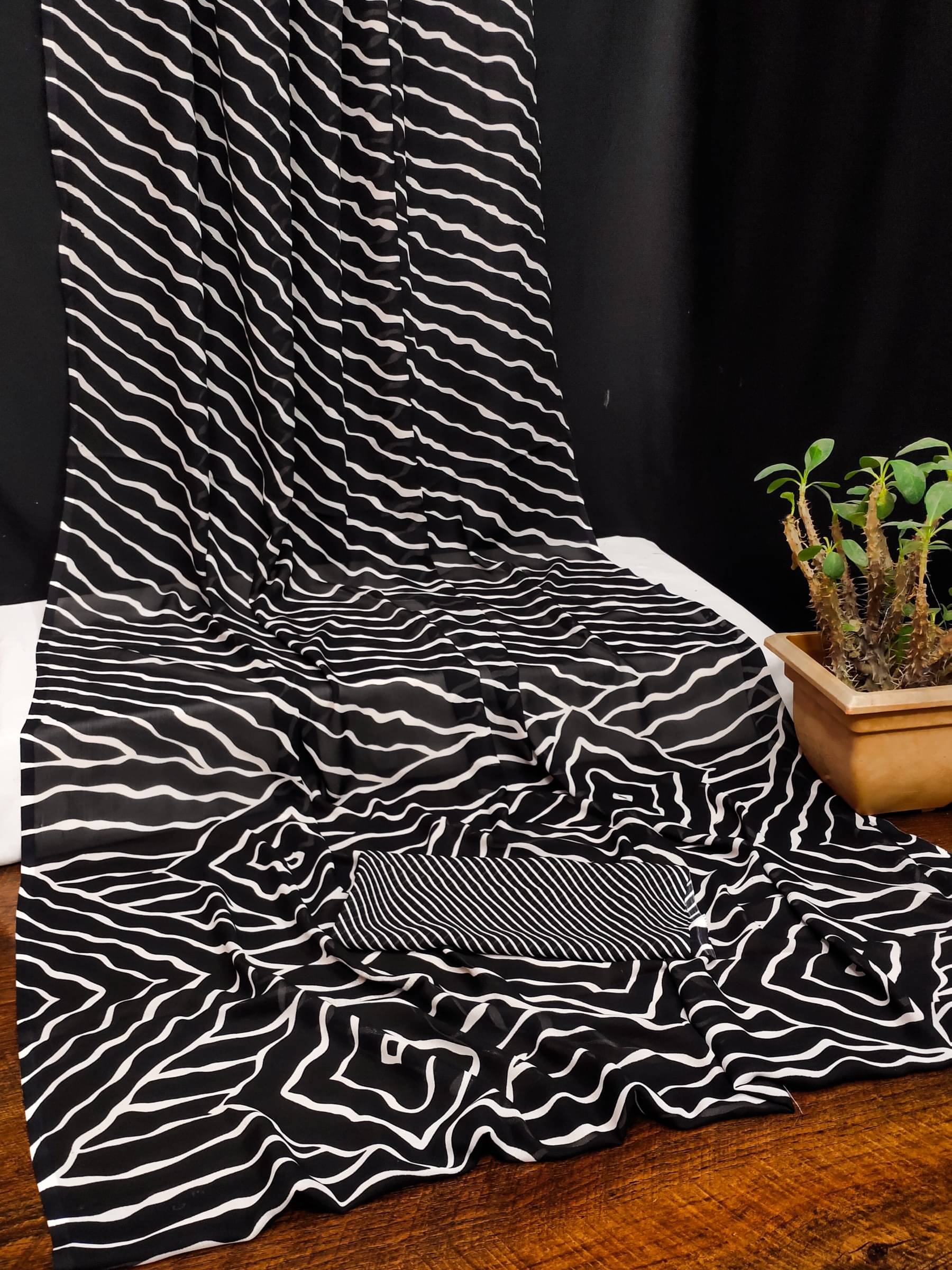 Kanooda Prints Georgette Printed Saree With Unstitched Blouse Piece ( Black )     			Kanooda Prints Georgette Printed Saree With Unstitched Blouse Piece ( Black )