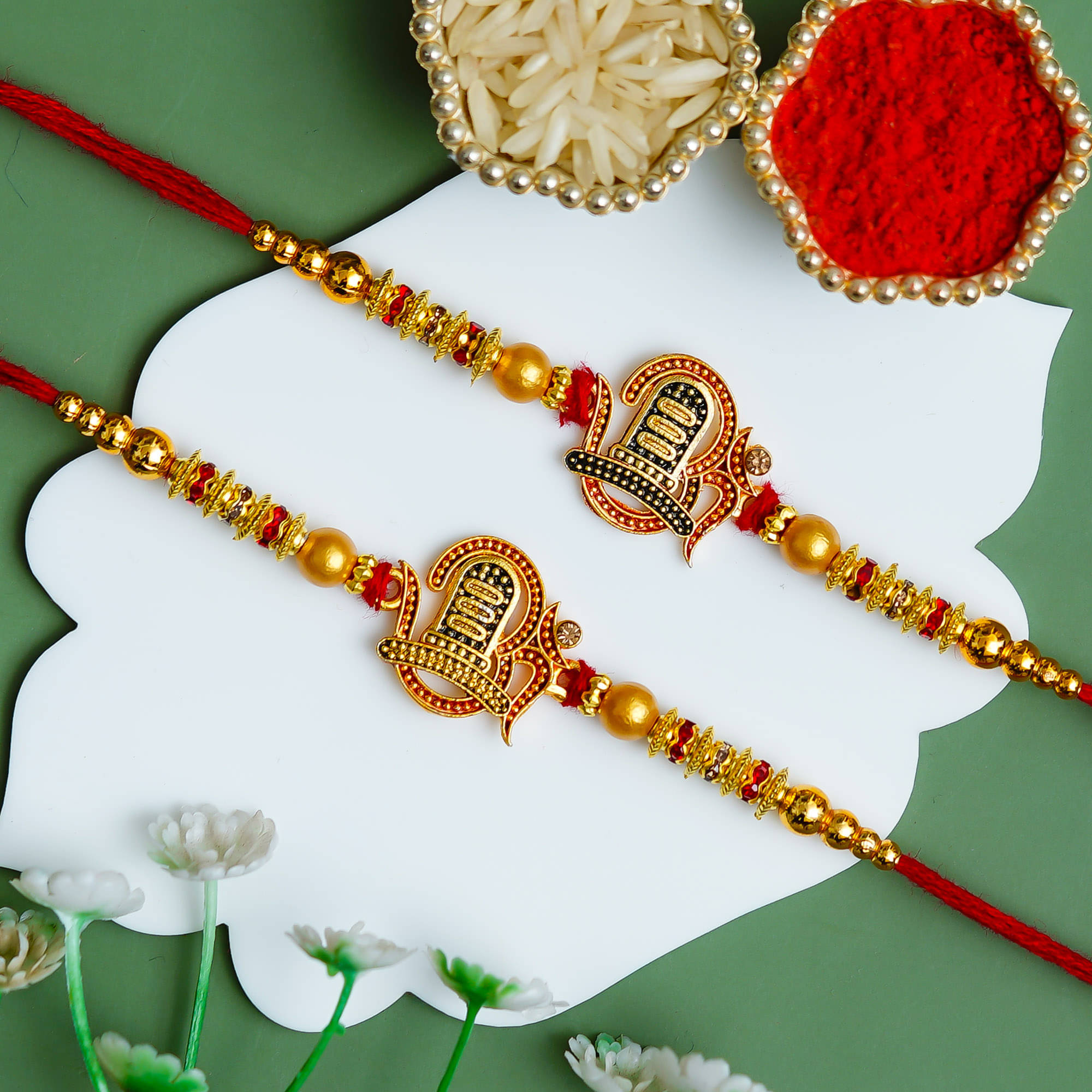     			Poorak Religious Assorted Rakhi Set of 2 – Trishul Design in Golden & Red with Roli Chawal