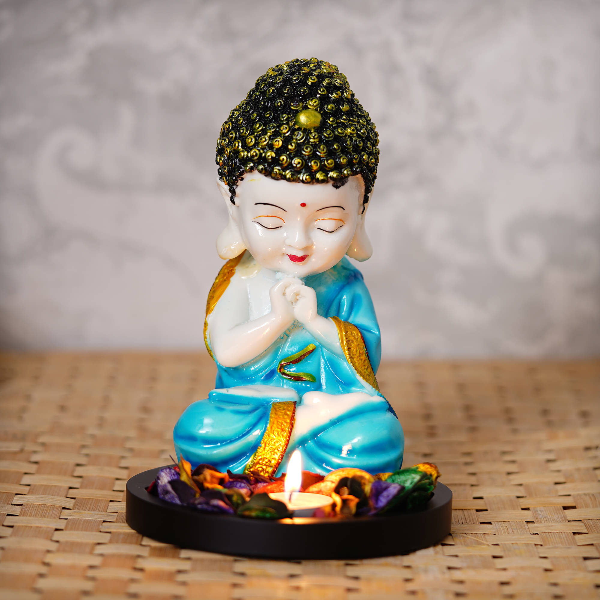 eCraftIndia Blue & Beige Praying Monk Buddha With Wooden Base Fragranced Petals & Tealight     			eCraftIndia Blue & Beige Praying Monk Buddha With Wooden Base Fragranced Petals & Tealight