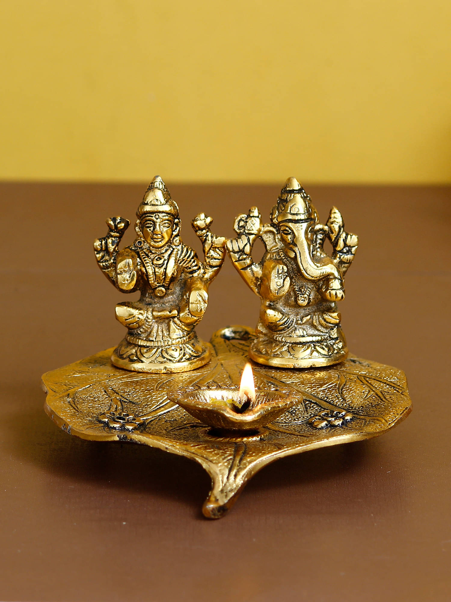 eCraftIndia Antique Gold-Toned Metal Handcrafted Laxmi Ganesh With Diya On Leaf eCraftIndia Antique Gold-Toned Metal Handcrafted Laxmi Ganesh With Diya On Leaf